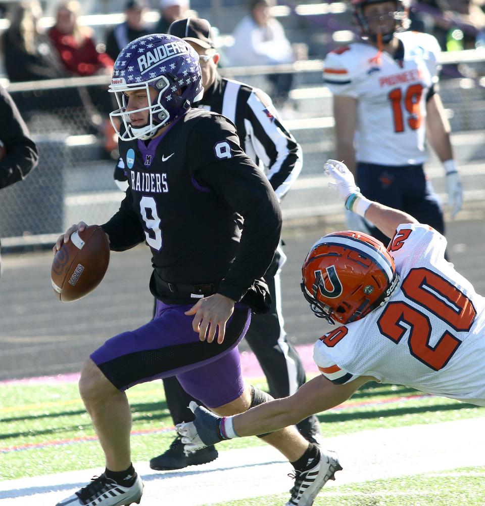 Mount Union Braxton Plunk runs the ball as Utica's Nick Billand dives for his feet during an NCAA Division III playoff game on Saturday, November 26, 2022.