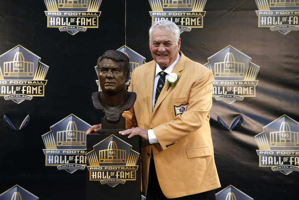 FILE - In this Aug. 8, 2015, file photo, former NFL player Mick Tingelhoff poses with his bust during the induction ceremony at the Pro Football Hall of Fame in Canton, Ohio. Tingelhoff, the ultimate ironman who started 240 consecutive games at a bruising position for the Minnesota Vikings and played in four Super Bowls, died, the Vikings and the Pro Football Hall of Fame announced, Saturday, Sept. 11, 2021. He was 81. (AP Photo/Gene J. Puskar, File)