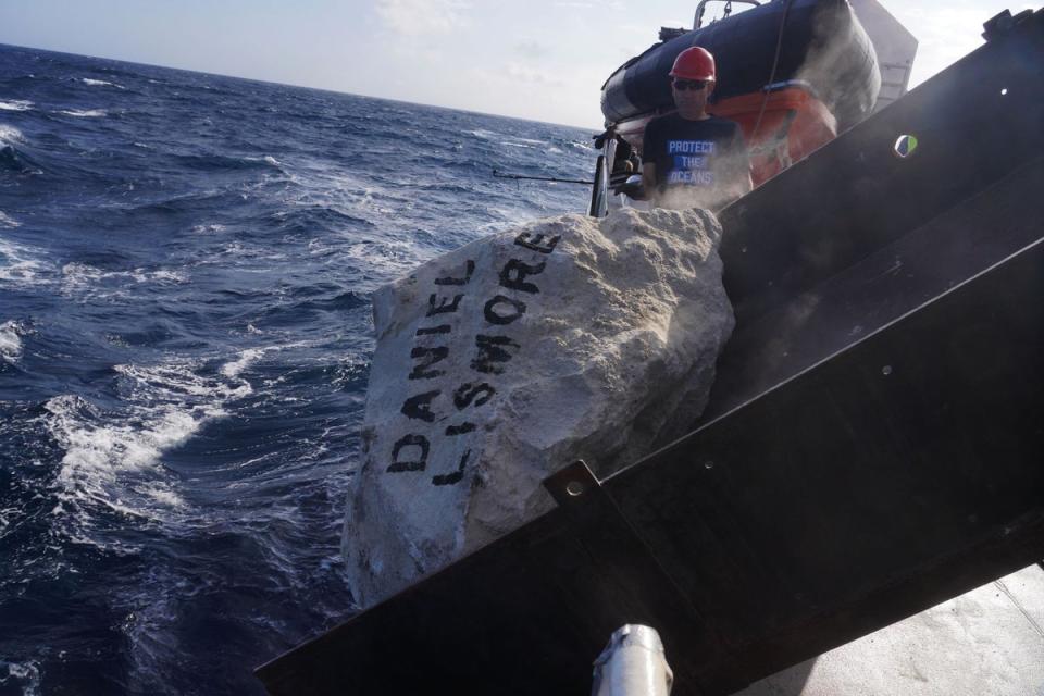 A boulder with Daniel Lismore’s name stencilled on it is dropped (Kristian Buus/Greenpeace) (PA Media)