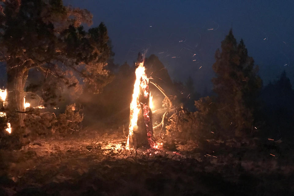 In this photo provided by the Bootleg Fire Incident Command, the Bootleg Fire burns at night near Highway 34 in southern Oregon on Thursday, July 15, 2021. Firefighters scrambled Friday to control a raging inferno in southeastern Oregon that's spreading miles a day in windy conditions, one of numerous wildfires across the U.S. West that are straining resources. The Bootleg Fire, the largest wildfire burning in the U.S., has torched more than 377 square miles (976 square kilometers), and crews had little control of it. (Jason Pettigrew/Bootleg Fire Incident Command via AP)