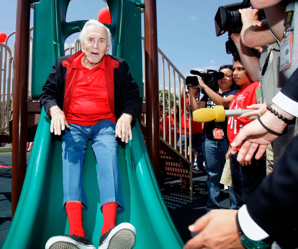 Actor Kirk Douglas tries-out a playground slide at Lillian Elementary School in Los Angeles Wednesday, May 28, 2008, after he and his wife donated  their 400th playground renovation to schools in the Los Angeles Unified School District. The 91-year-old Douglas and his wife Anne have donated a renovation a week over an 11-year period beginning in 1997. The couple provides a grant of $25,000 per playground, with the school's parents or supporters matching the amount in money or services. (AP Photo/Nick Ut) ORG XMIT: LA105