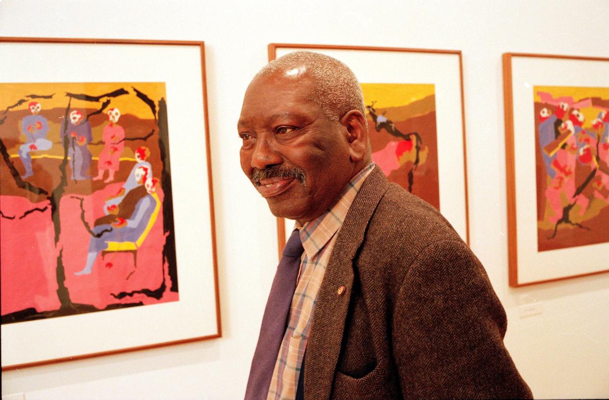 Artist Jacob Lawrence stands among his paintings from the "Migration Series" at New York's Payson Gallery on Nov. 19, 1993.