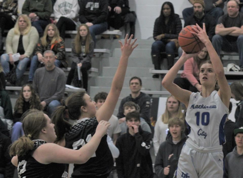 Mackinaw City senior forward Madison Smith (10) shoots over a pair of Cedarville defenders during the first half on Friday.