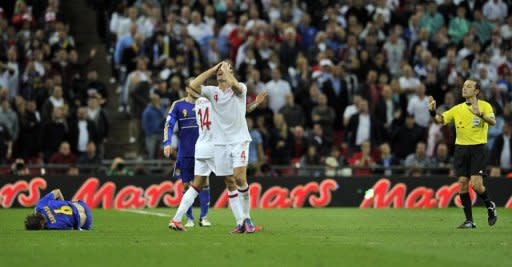 England captain Steven Gerrard reacts after realising he is about to receive a red card from referee Cuneyt Cakir (R) during England's World Cup qualifying match against Ukraine on September 11