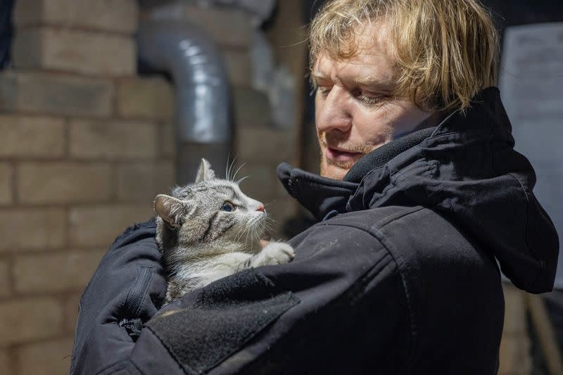 FOTO DE ARCHIVO: El fotógrafo ucraniano Maksim Levin sostiene un gato cerca de la línea de separación de los separatistas apoyados por Rusia en la región de Luhansk, Ucrania