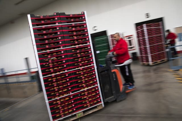 Workers move boxes containing tomatoes inside a warehouse in Andalusia