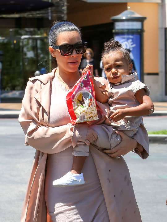 Kim Kardashian and North West match in khaki for a trip to the movies.