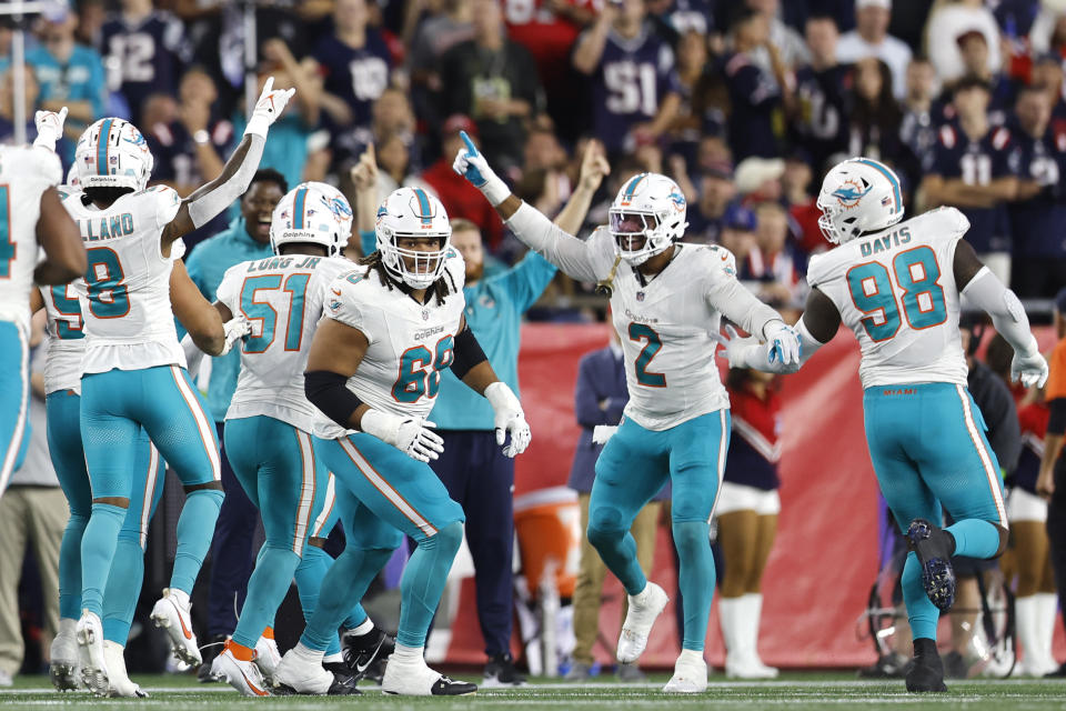 Miami Dolphins celebrate after an interception by cornerback Xavien Howard against the New England Patriots during the second half of an NFL football game, Sunday, Sept. 17, 2023, in Foxborough, Mass. (AP Photo/Michael Dwyer)