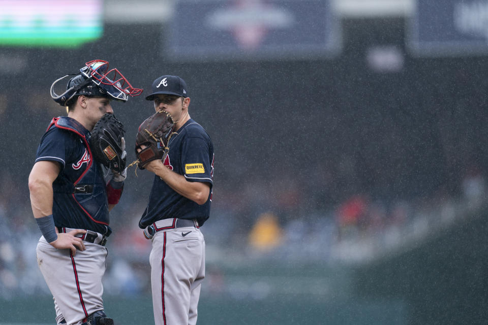 Atlanta Braves catcher Sean Murphy, left, and starting pitcher Allan Winans, right, talk on the mound in the rain during the fourth inning of a baseball game against the Washington Nationals, Sunday, Sept. 24, 2023, in Washington. (AP Photo/Stephanie Scarbrough)