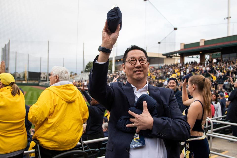 U-M president Santa Ono throws free t-shirts into the crowd during a Fiesta Bowl pep rally at Scottsdale Stadium in Scottsdale on Dec. 30, 2022.