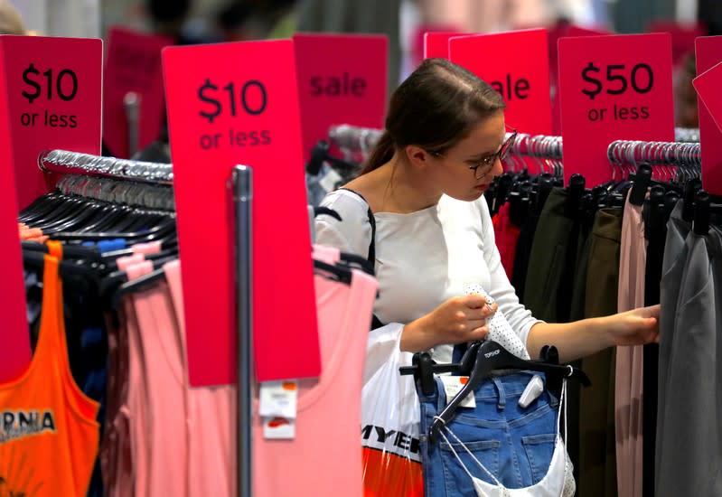 FILE PHOTO: A shopper holds items and looks at others on sale at a clothing retail store in central Sydney, Australia