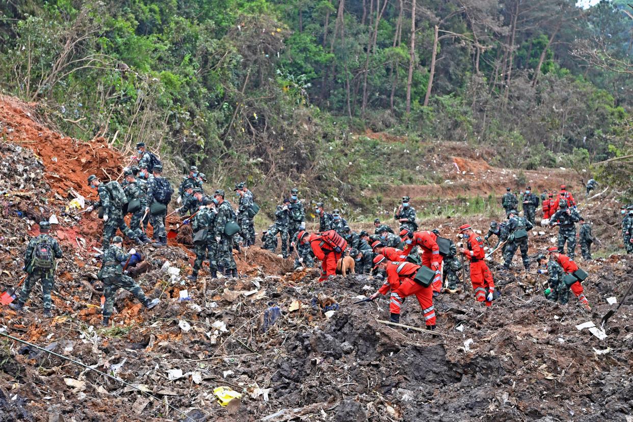 In this photo released by Xinhua News Agency, rescue workers search for the black boxes at a plane crash site in Tengxian county, southwestern China's Guangxi Zhuang Autonomous Region, Tuesday, March 22, 2022.