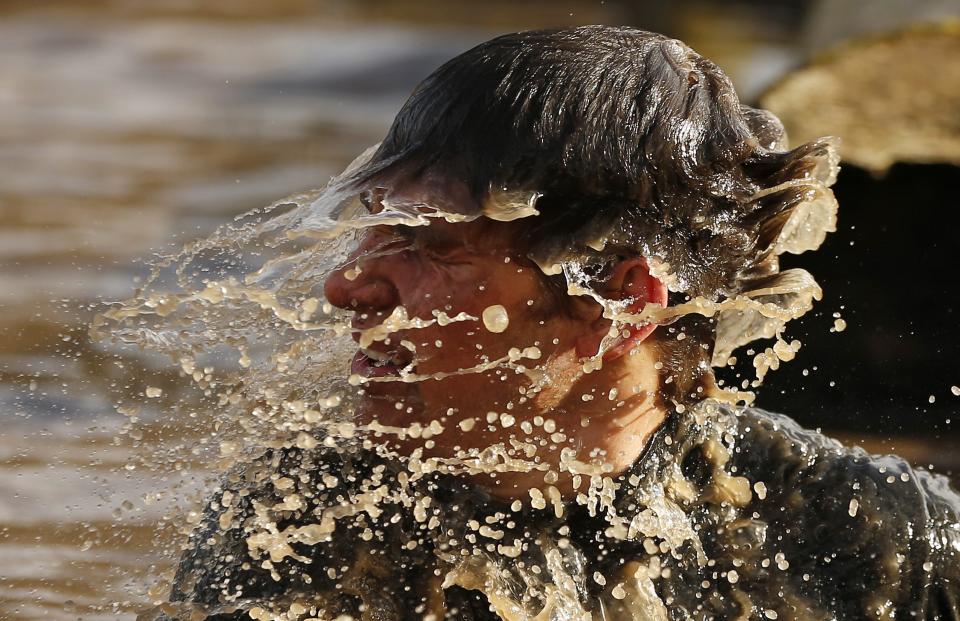 A competitor shakes water off his head during the Tough Guy event in Perton, central England