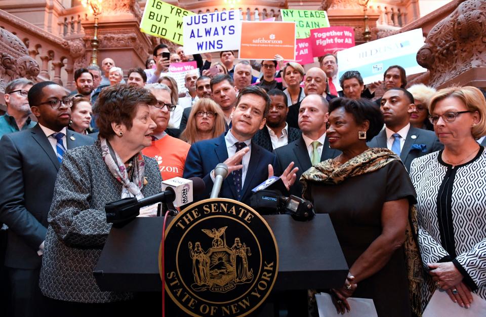 New York Sen. Brad Hoylman, D-Manhattan, center, flanked by former Assemblywoman Margaret Markey, left, and Senate Majority Leader Andrea Stewart-Cousins, D-Yonkers, right, stands with survivors and advocates speaking in favor of passing legislation authorizing the Child Victims Act during a news conference at the state Capitol in Albany, New York, on Monday, Jan. 28, 2019.