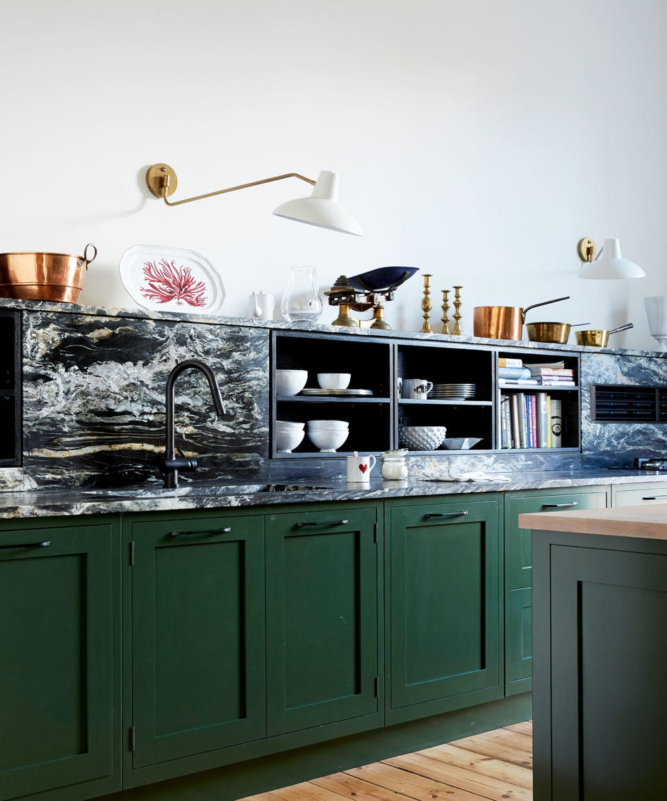 Kitchen with green cabinets and marble backsplash with storage