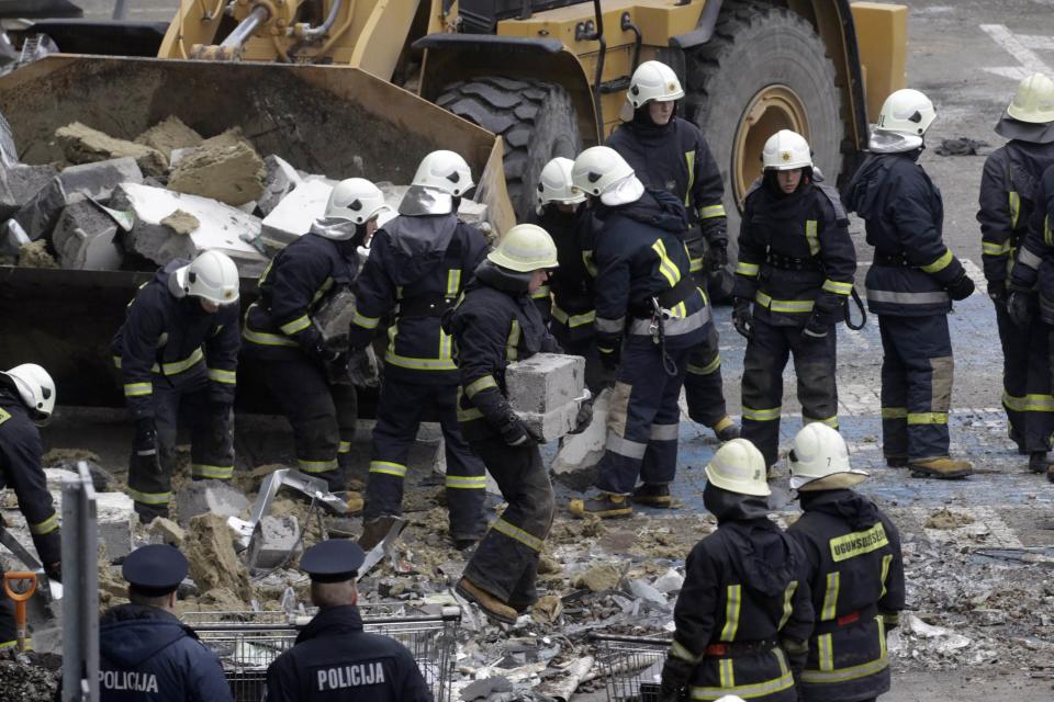 Firefighters remove debris from a collapsed supermarket in capital Riga