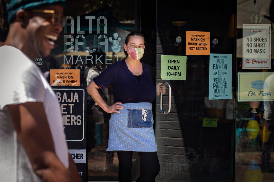 Delilah Snell stands at the front door of her store, where she has enforced a mask mandate since the start of the pandemic.