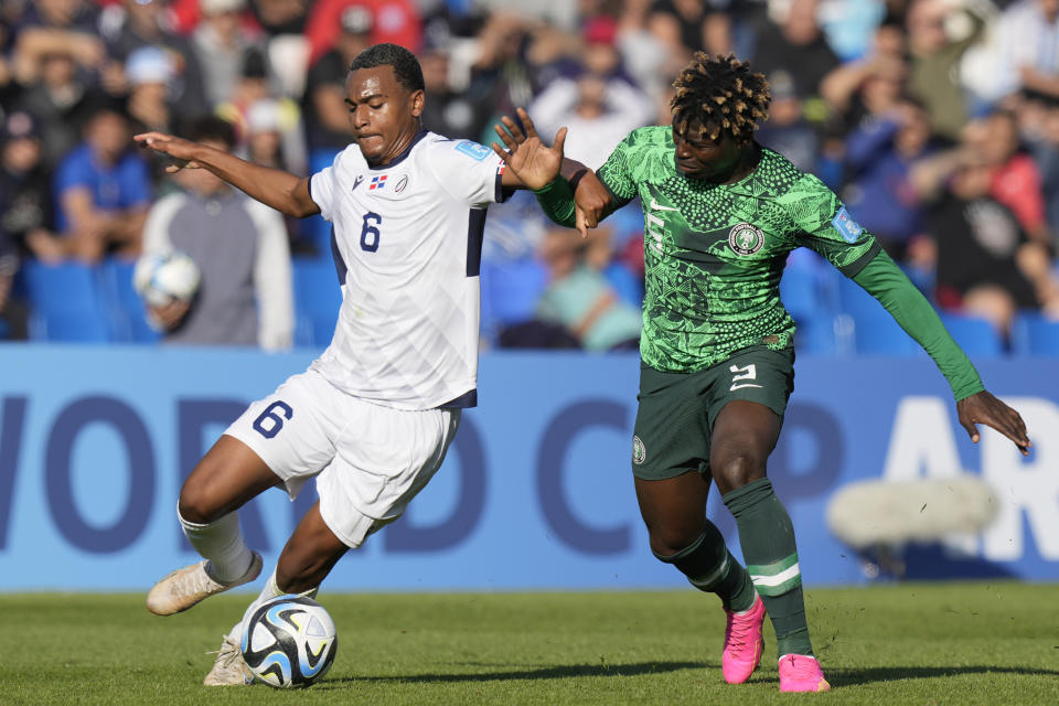 El dominicano Israel Boatwright (izquierda) y el nigeriano Abel Ogwuche pugnan por el balón en el partido del Mundial Sub20, el domingo 21 de mayo de 2023, en Mendoza, Argentina. (AP Foto/Natacha Pisarenko)