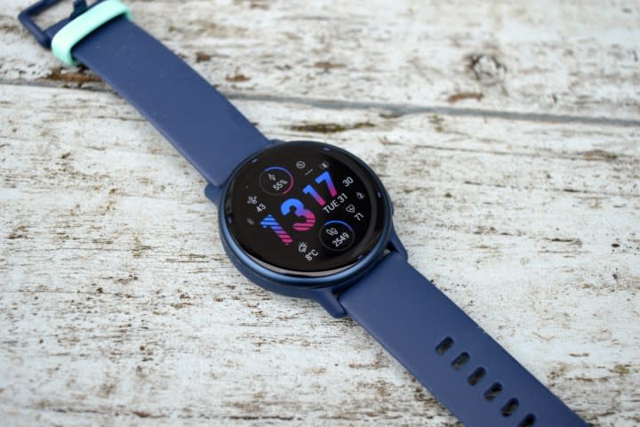 The Garmin Vivoactive 5 laid down on painted wood, face up.