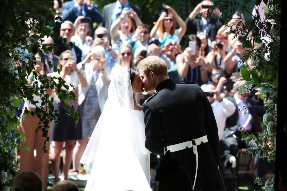 Prince Harry and Meghan Markle kiss on the steps of St George's Chapel in Windsor Castle (PA)