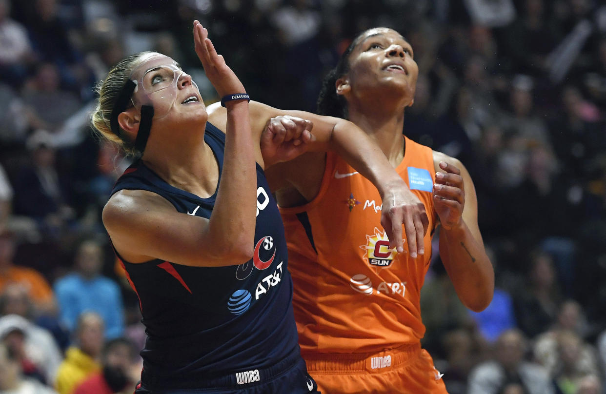 Washington Mystics' Elena Delle Donne, left, and Connecticut Sun's Jasmine Thomas fight for position under the basket during the first half in Game 4 of basketball's WNBA Finals, Tuesday, Oct. 8, 2019, in Uncasville, Conn. (AP Photo/Jessica Hill)