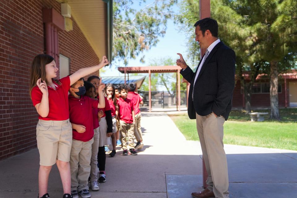 Ashlynn Shoemaker, 6, greets Tony Alcala, principal of Galveston Elementary School, as the kindergarten class makes its way back to class after recess at Galveston Elementary School on April 6, 2022, in Chandler.