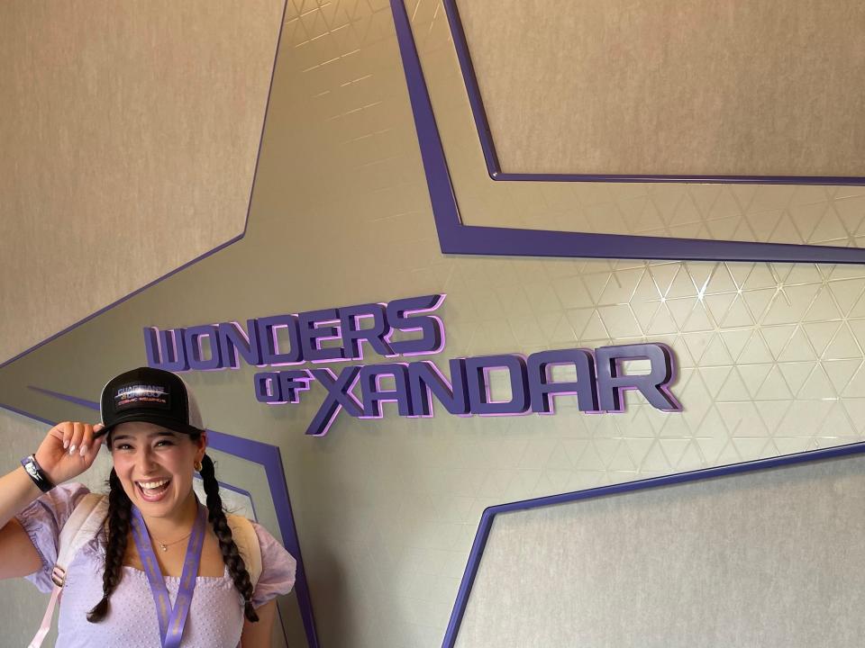josephine posing with the wonders of xandar sign at cosmic rewind ride epcot