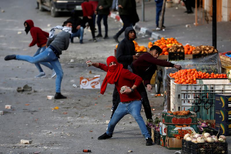 FILE PHOTO: Palestinian demonstrators hurl stones at Israeli forces during a protest against the U.S. President Donald Trump’s Middle East peace plan, in Hebron in the Israeli-occupied West Bank
