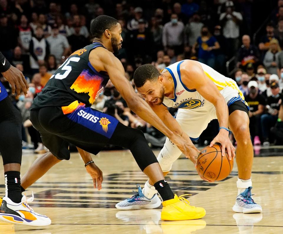 Nov 30, 2021; Phoenix, Arizona, USA; Phoenix Suns forward Mikal Bridges (25) pressures Golden State Warriors guard Stephen Curry (30) at Footprint Center.