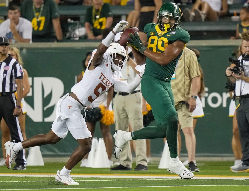 Texas defensive back Malik Muhammad rips the ball out of Baylor tight end Drake Dabney's hands during the Longhorns' 38-6 win Saturday in Waco. Muhammad is one of several true freshmen who will burn their redshirt season by playing against Kansas this weekend.