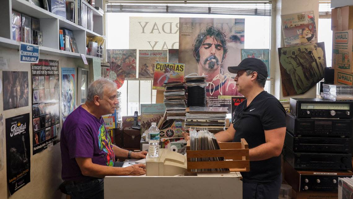 Yesterday and Today Records owner Evan Chern, left, talks to costumer Daniel Garcia inside his record store on west Bird Road at 9274 SW 40th St. in Miami, Florida, on Feb. 2, 2024. Y&T is the oldest record store in Miami-Dade County and will be hosting Record Store Day on April 20, 2024.