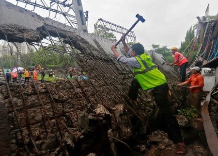 Rescue and railway workers seen working at the site of an overbridge that collapsed over the railway tracks after heavy rains in Mumbai, India July 3, 2018. REUTERS/Danish Siddiqui