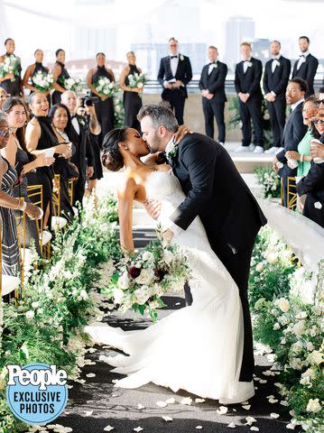 <p>Hunter Hennes Photography</p> Devyn Simone and husband Adam Lock kiss at their Kansas City wedding on June 24, 2023