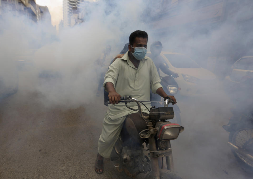 Disinfectant is sprayed in a market area in an effort to contain the outbreak of the coronavirus, in Karachi, Pakistan, Monday, Aug. 2, 2021. (AP Photo/Fareed Khan)