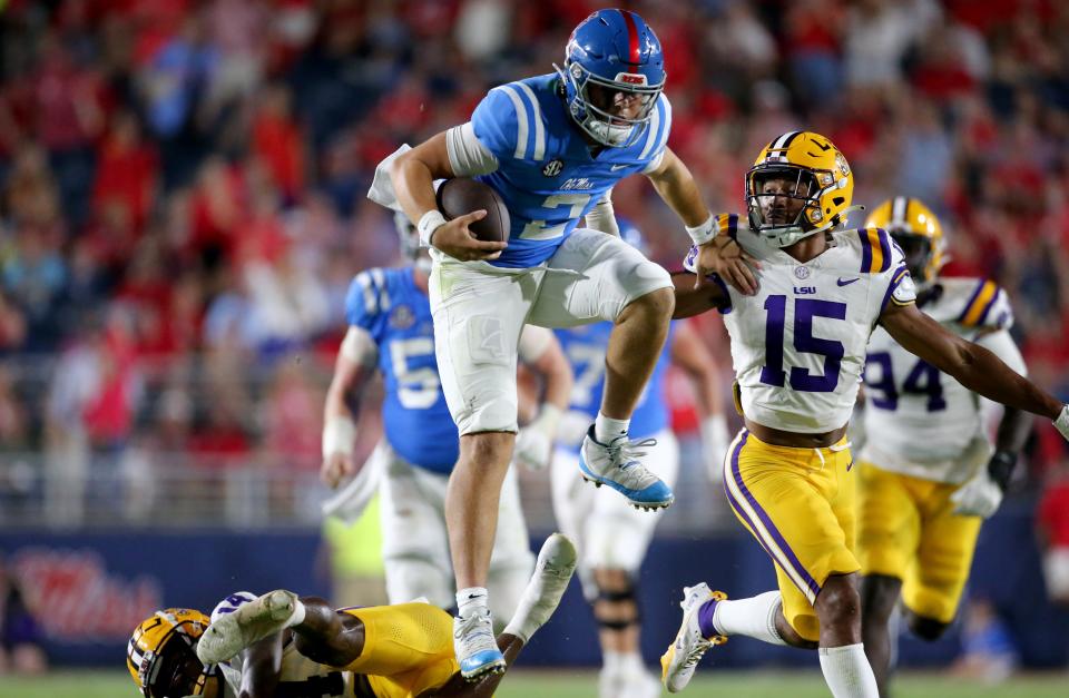 Sep 30, 2023; Oxford, Mississippi, USA; Mississippi Rebels quaterback Jaxson Dart (2) leaps over LSU Tigers defensive back Andre’ Sam (14) during the second half at Vaught-Hemingway Stadium. Mandatory Credit: Petre Thomas-USA TODAY Sports