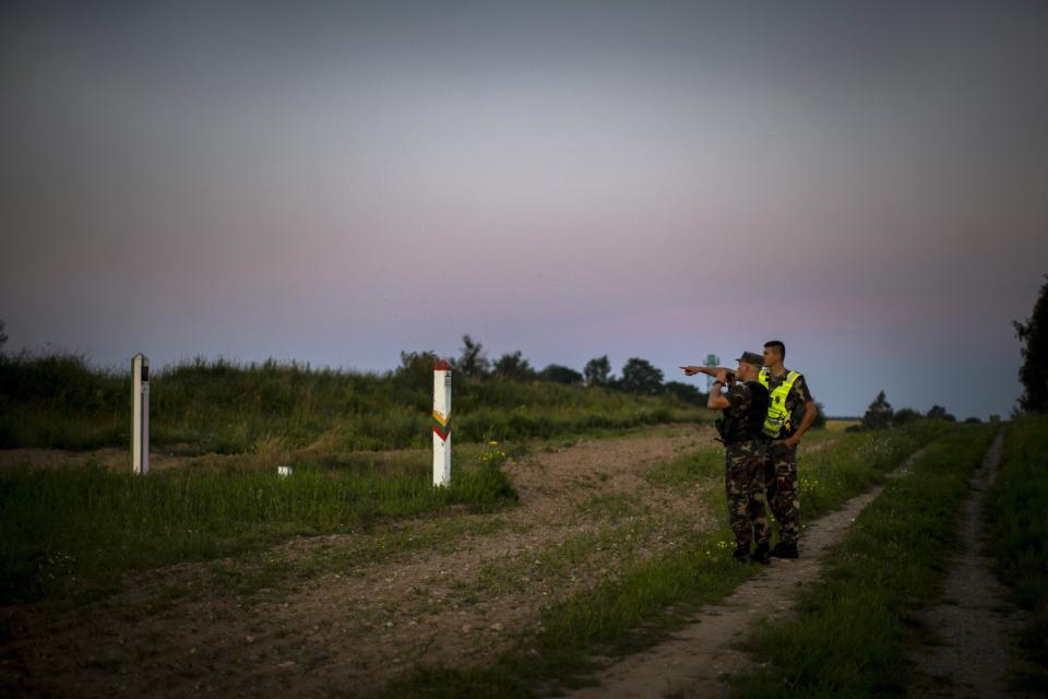 FILE In this file photo taken on Saturday, July 10, 2021, Members of the Lithuania State Border Guard Service patrol on the border with Belarus with a Belarusian, left, and Lithuanian, center, border markers, near the village of Purvenai, Lithuania. Daily arrivals sometimes reach triple digits as migrants appear in the woods in front of Lithuanian border guards, run into local mushroom pickers or simply walk into towns. There are nearly 1,700 asylum seekers, most having arrived in recent weeks, compared with only 80 for all of 2020. (AP Photo/Mindaugas Kulbis, File)