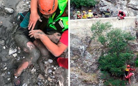 A girl is helped by a member of the National Alpine and Caving Rescue Squad as they (right) descend the gorge - Credit: ANSA/AP