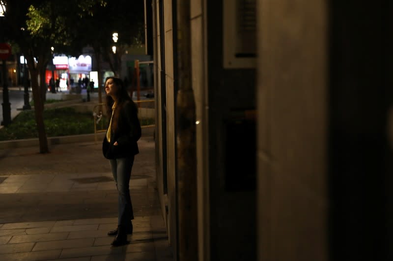 A passerby stops to listen to Spanish blues singer "Betta" sing from her balcony during a daily evening concert to support health workers and to make it easier for her neighbours to bear the coronavirus lockdown in Madrid
