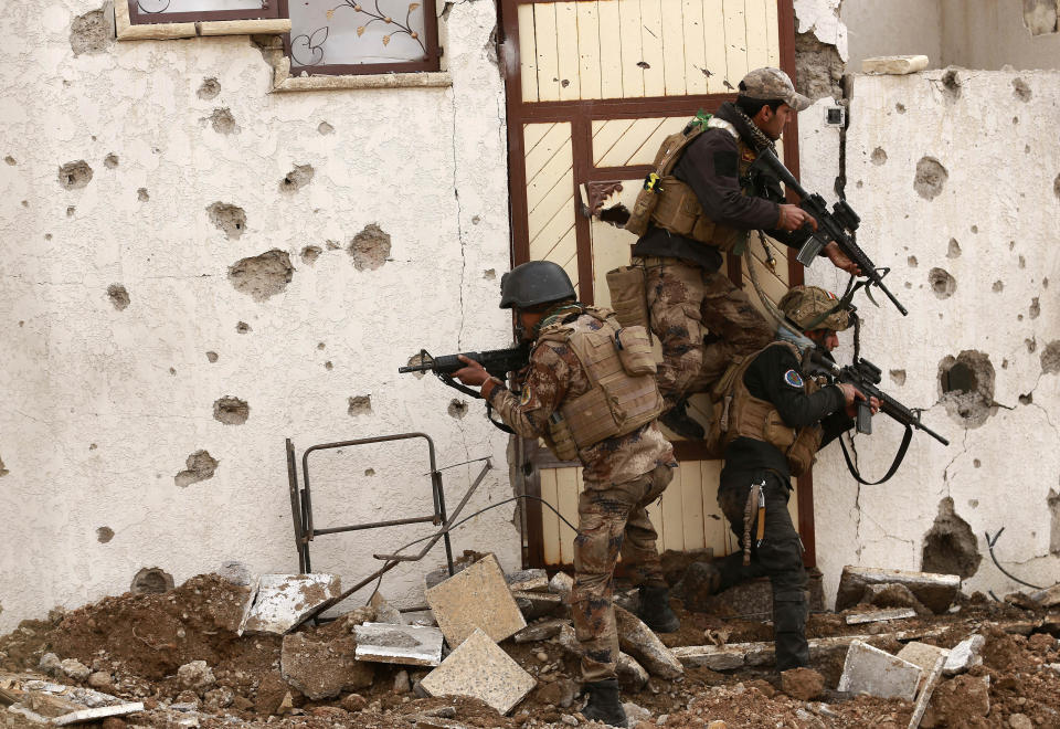 FILE - Soldiers with Iraq's elite counterterrorism forces secure houses and streets during fighting against Islamic State militants to regain control of the eastern neighborhoods of Mosul, Iraq, Dec. 13, 2016. Ten years after the Islamic State group declared its caliphate in large parts of Iraq and Syria, the extremists now control no land, have lost many prominent founding leaders and are mostly away from the world news headlines. (AP Photo/Hadi Mizban, File)