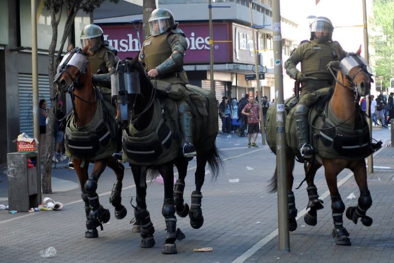 Officers of the mounted Chilean police charge toward demonstrators during a protest against social inequality in Concepcion