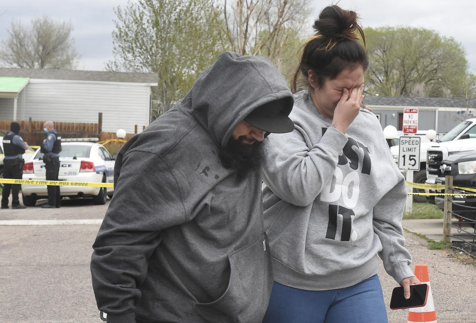 Freddy Marquez kisses the head of his wife, Nubia Marquez, near the scene where her mother and other family members were killed in a mass shooting early Sunday, May 9, 2021, in Colorado Springs, Colo. The suspected shooter was the boyfriend of a female victim at the party attended by friends, family and children. He walked inside and opened fire before shooting himself, police said. Children at the attack weren’t hurt and were placed with relatives. (Jerilee Bennett/The Gazette via AP)