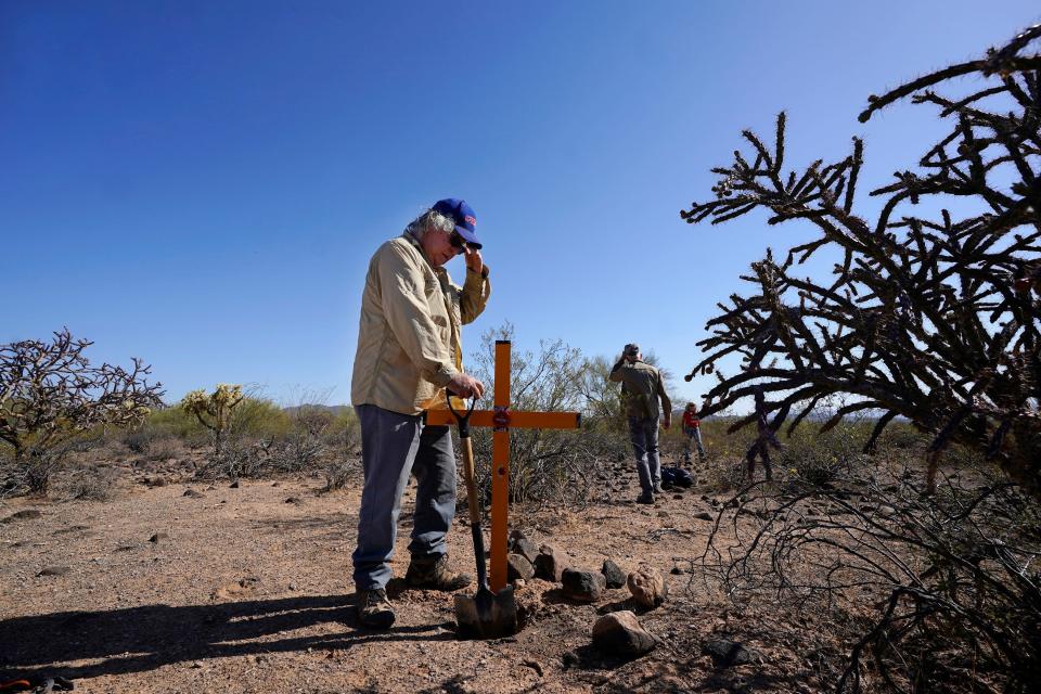 Alvaro Enciso, part of the Tucson Samaritans volunteer group, pauses as he and a group of other volunteers place a new cross at the site of the migrant who died in the desert some time ago, on Tuesday, May 18, 2021, in the desert near Three Points, Ariz.