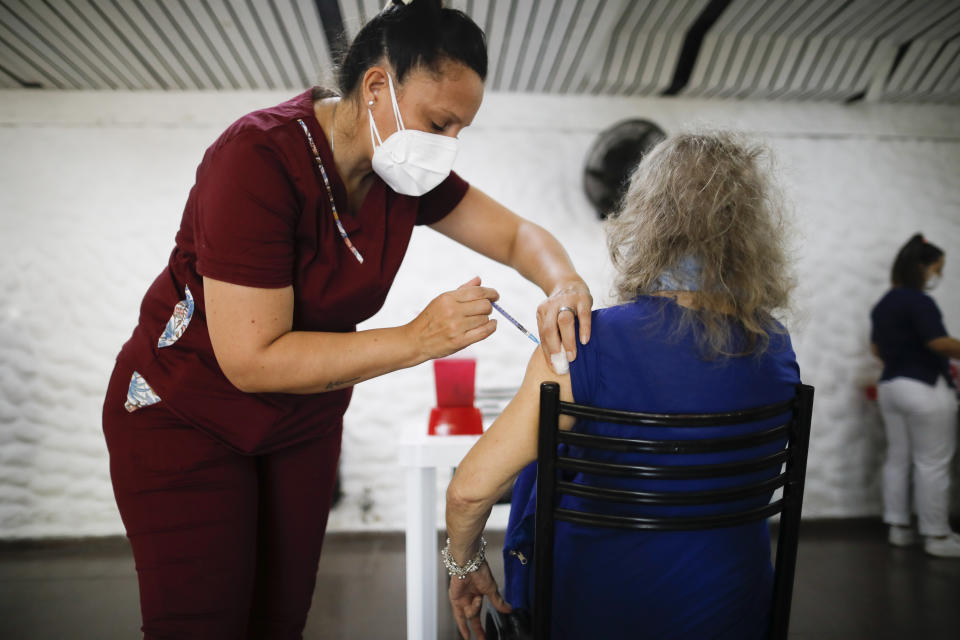 Carmela Corleto gets her first shot of the AstraZeneca vaccine for COVID-19 at a vaccination center in Almirante Brown, Argentina, Friday, April 23, 2021. (AP Photo/Natacha Pisarenko)