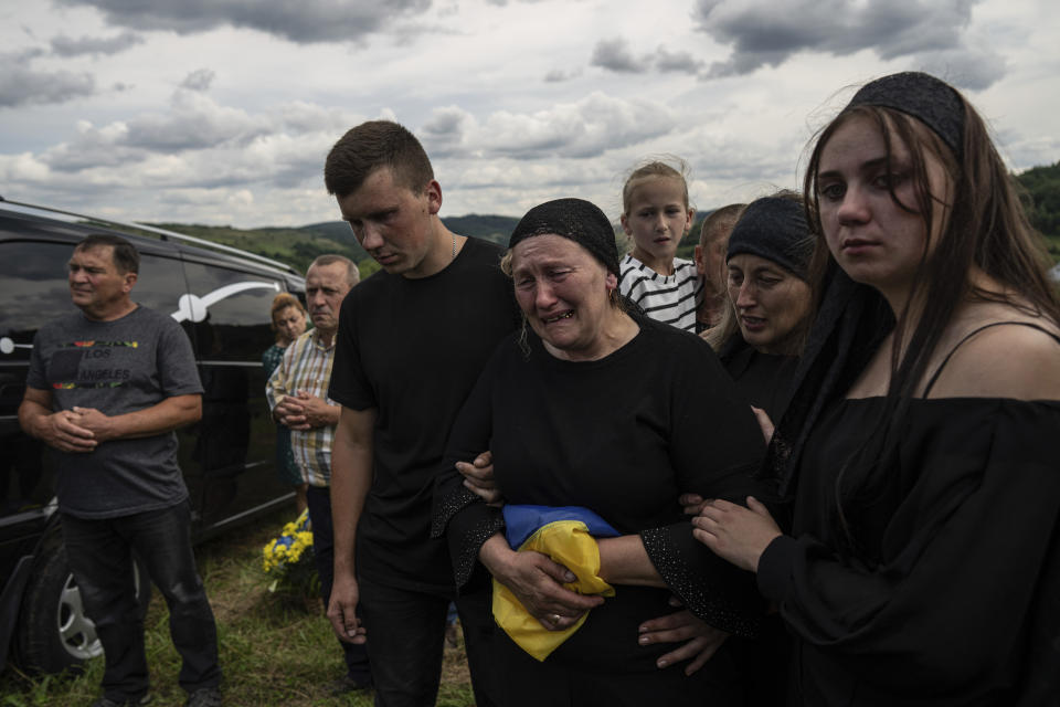 FILE - Myroslava cries during the burial of her son Stepan Tymchyshak, a Ukrainian serviceman who was killed at the frontline near Kupiansk, during funeral ceremony in Opak, Ukraine, Sunday, July 23, 2023. Battles in recent weeks have taken place on multiple points along the 1,500-kilometer (930-mile) front line as Ukraine wages a counteroffensive with Western-supplied weapons and Western-trained troops against Russian forces who invaded 17 months ago. (AP Photo/Evgeniy Maloletka, File)