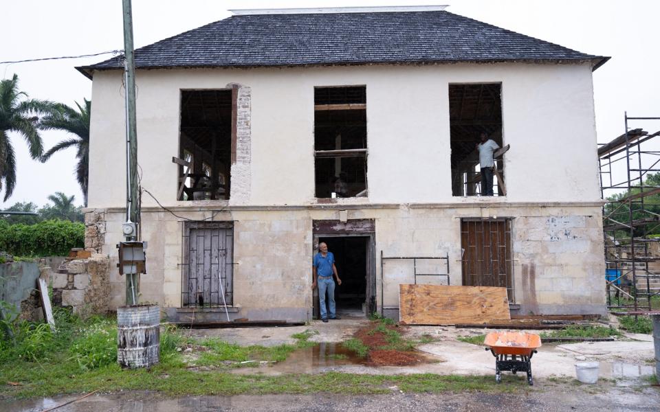 Gutted shell of Tharp House with people working on it