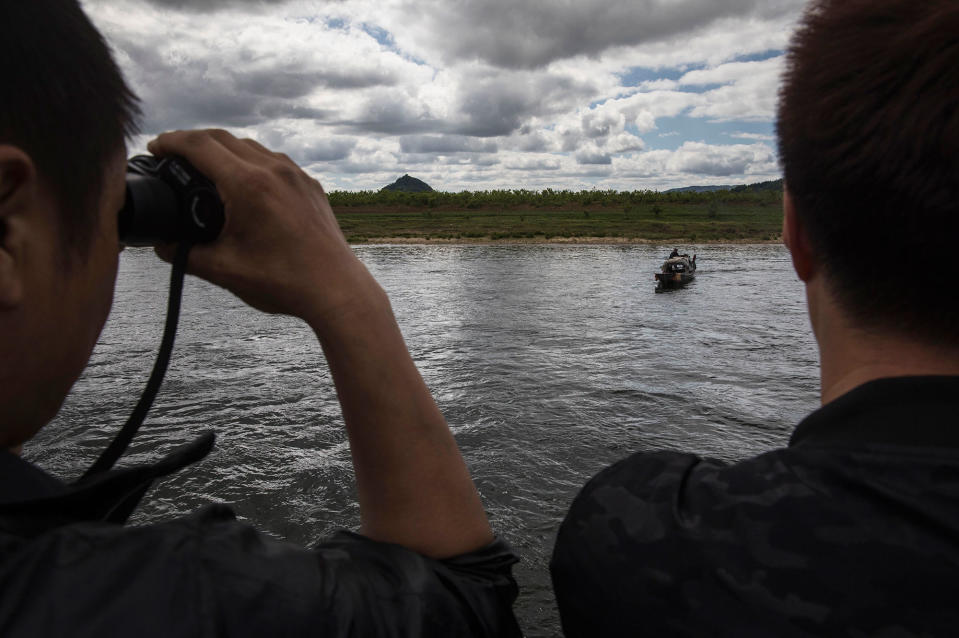 <p>Chinese tourists look at a North Korean fisherman as they ride in a boat on the Yalu river with North Korean territory on both sides north of the border city of Dandong, Liaoning province, northern China across from the city of Sinuiju, North Korea on May 23, 2017 in Dandong, China. (Photo: Kevin Frayer/Getty Images) </p>