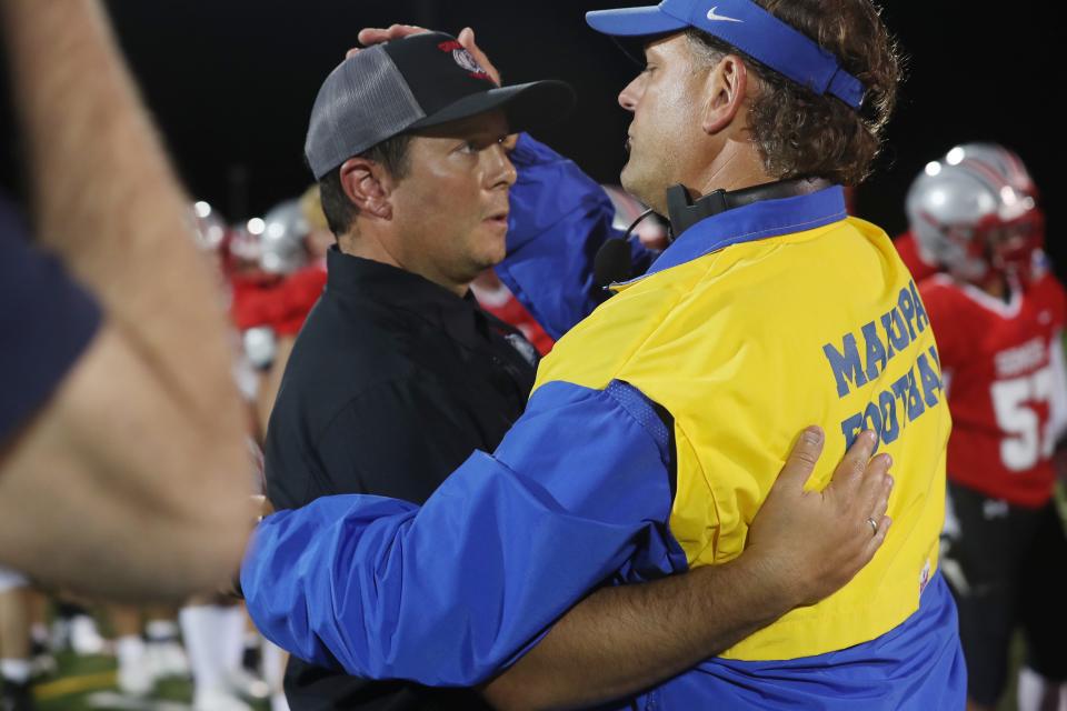 From right, Mahopac coach Dominick DeMatteo hugs his brother, Somers coach Anthony DeMatteo, after the two brothers faced off against each other in the season opener at Somers High School Sept. 10, 2021.