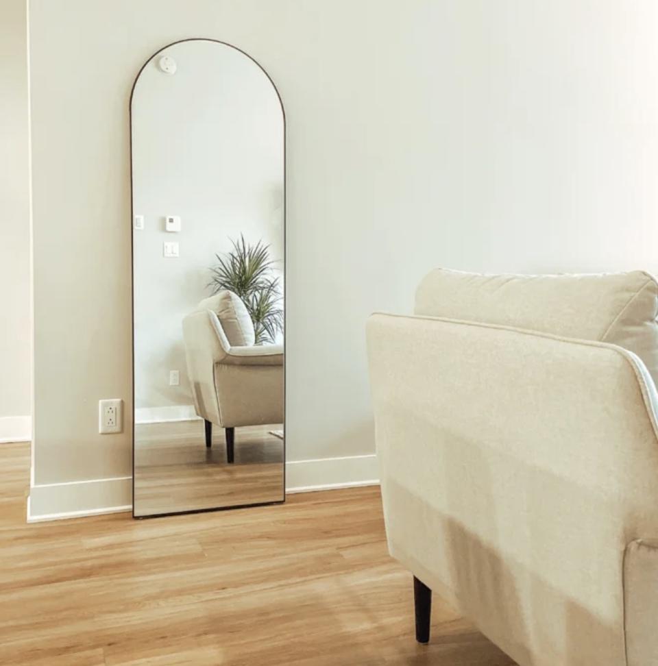 A reviewer's floor length mirror against a wall in a living room