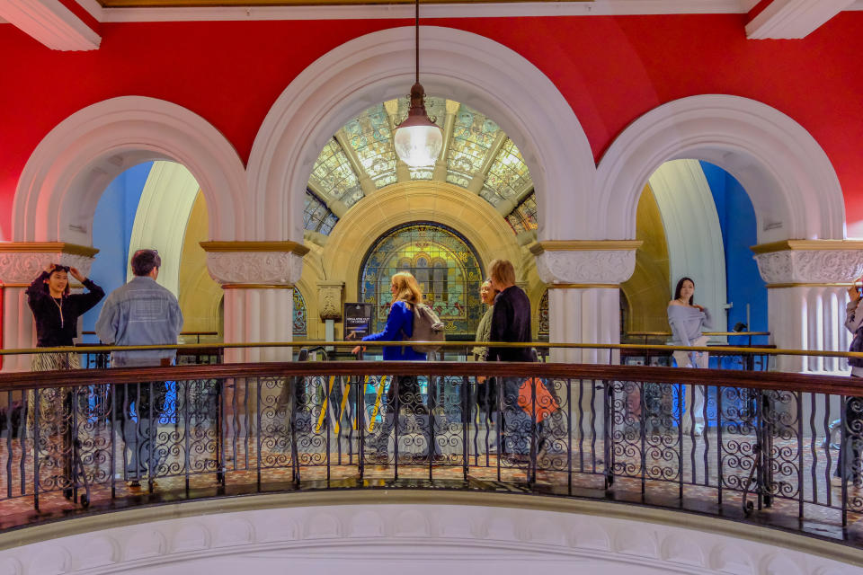 People walking inside a building with arches