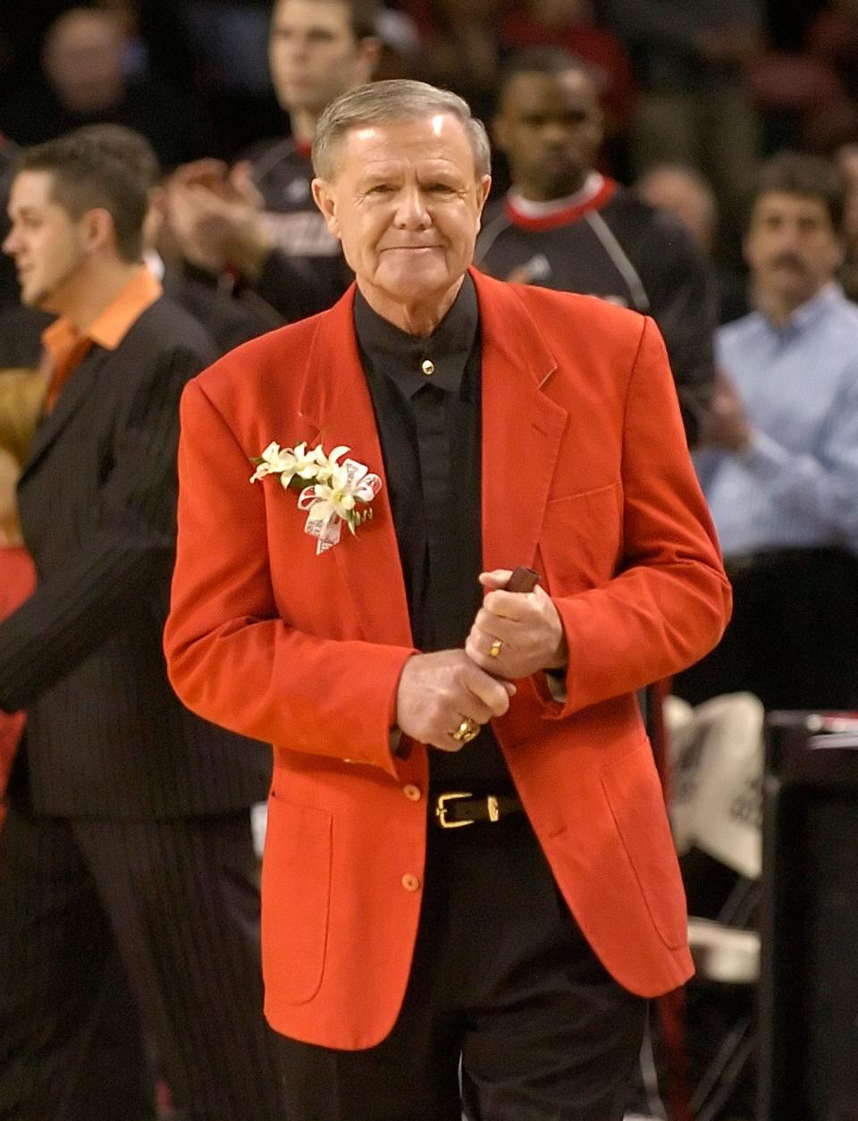 Holding his trademark rolled up program, former Louisville basketball coach Denny Crum takes the floor for a ceremony naming the court in his honor.